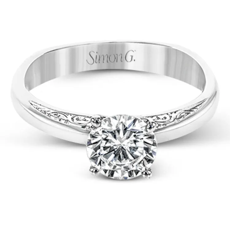 Beautiful in its simplicity, this sleek white gold ring accentuates its centerpiece with delicate engraved details on either side.
