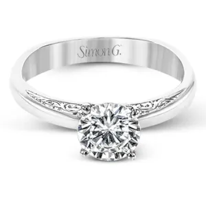 Beautiful in its simplicity, this sleek white gold ring accentuates its centerpiece with delicate engraved details on either side.