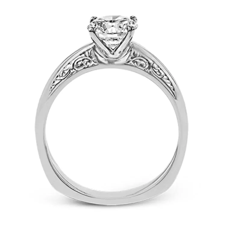 Beautiful in its simplicity, this sleek white gold ring accentuates its centerpiece with delicate engraved details on either side.